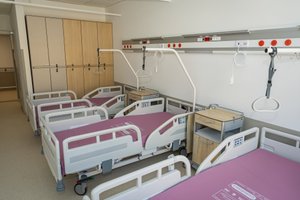 Nowoczesna sala szpitalna z łóżkami.